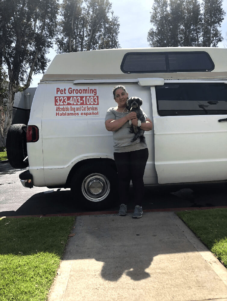 Woman in front of mobile pet grooming van